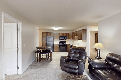 A living room with a black leather couch and chair.