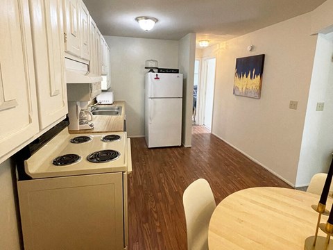 a kitchen with a stove and a refrigerator and a dining room table
