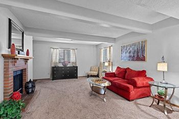 a living room with a red couch and a fireplace