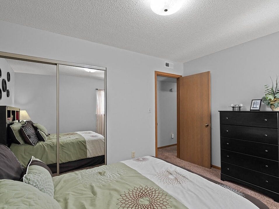 a bedroom with a large bed and a mirror