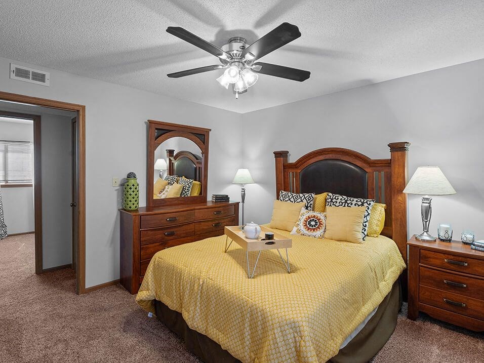 a bedroom with a bed and a ceiling fan