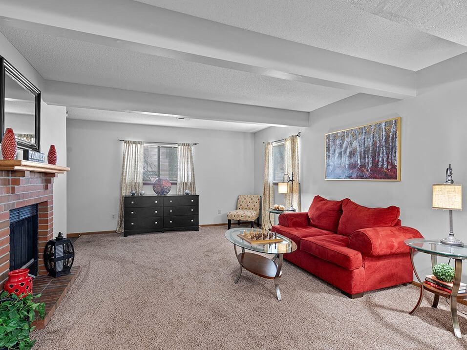a living room with a red couch and a fireplace