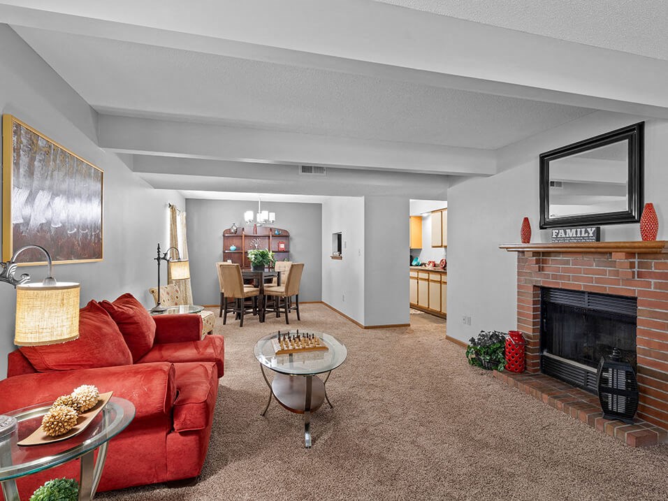 a living room with a red couch and a fireplace