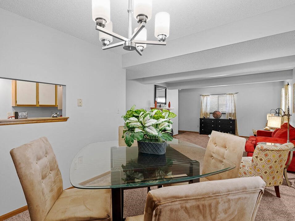 a living room with a glass table and chairs