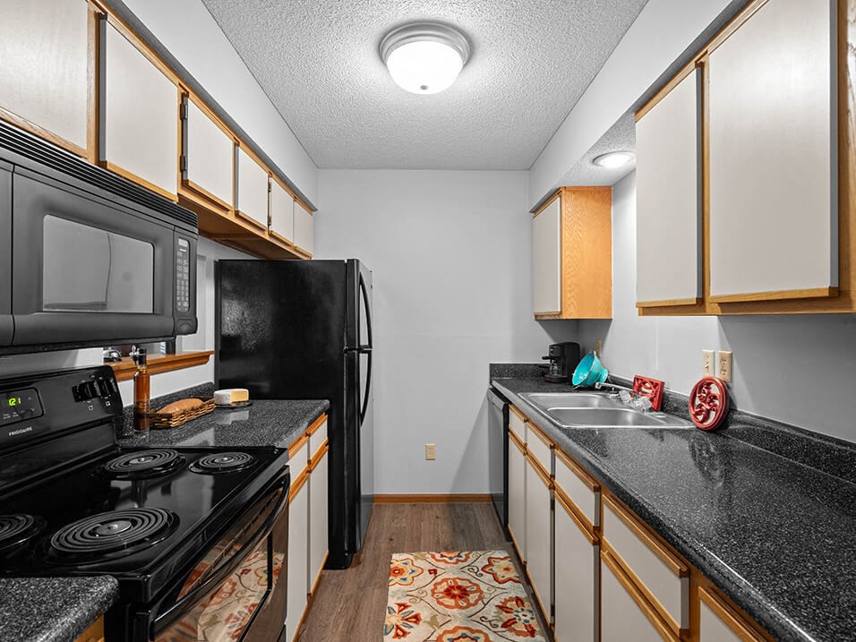 a kitchen with black appliances and granite counter tops