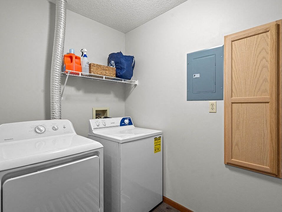 a white laundry room with a washer and dryer and a blue cabinet