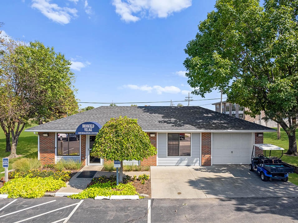 a small brick building with a blue sign and a parking lot