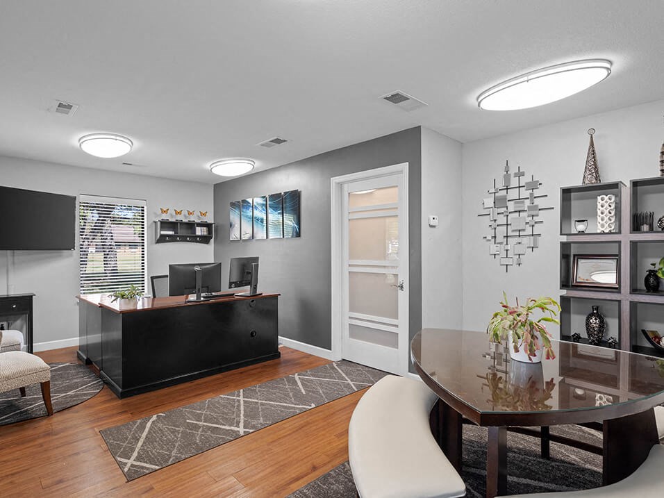 a living room with a table and a desk
