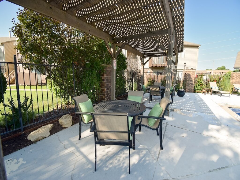 a covered patio with a table and chairs