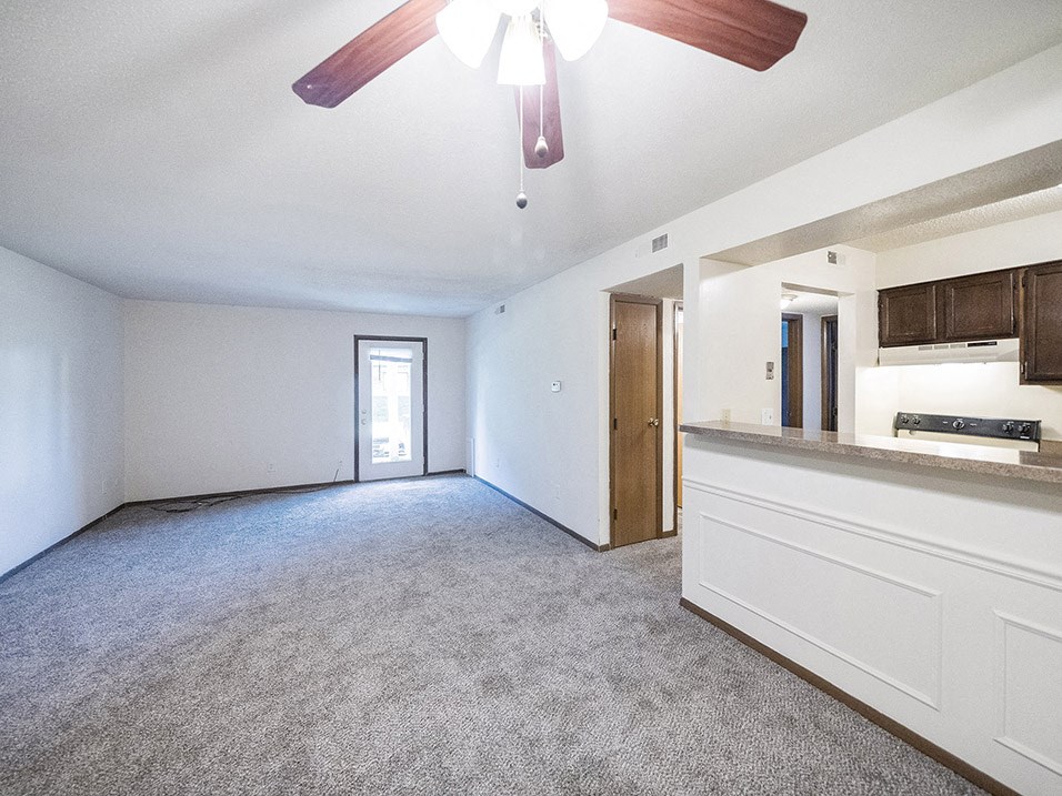 Spacious living room by kitchen with overhead light