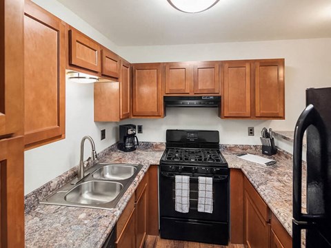 a kitchen with wooden cabinets and a stove and sink