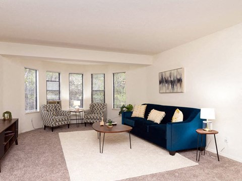 a living room with a blue couch and chairs