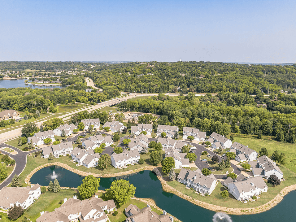 an aerial view of a neighborhood with houses and a lake
