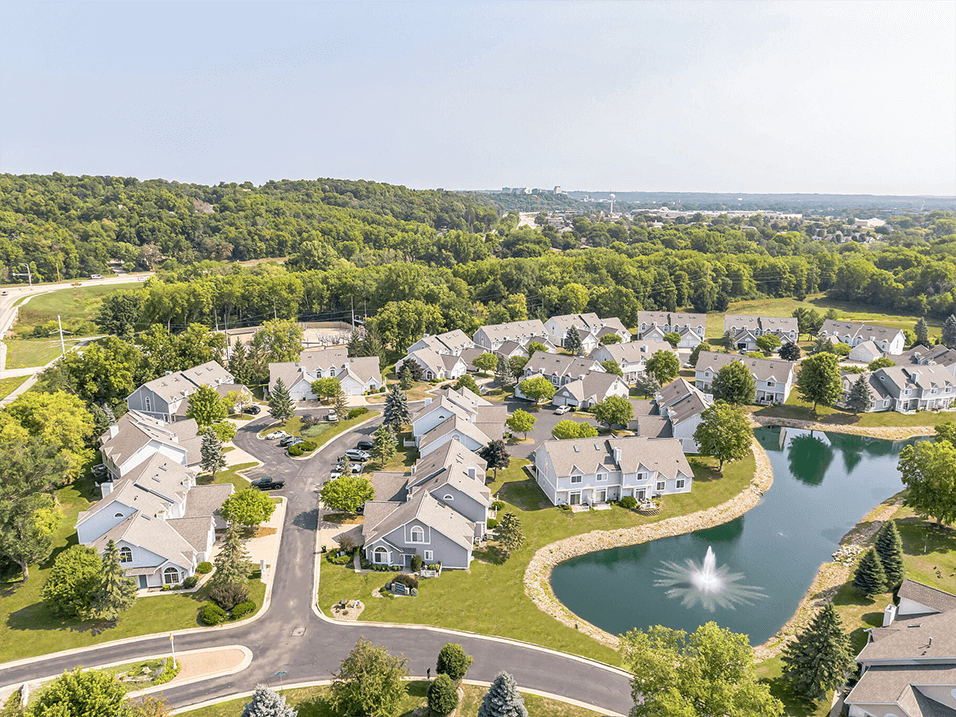 an aerial view of a neighborhood of houses next to a lake