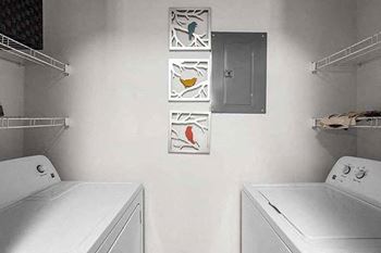 a white laundry room with two washes and a dryer