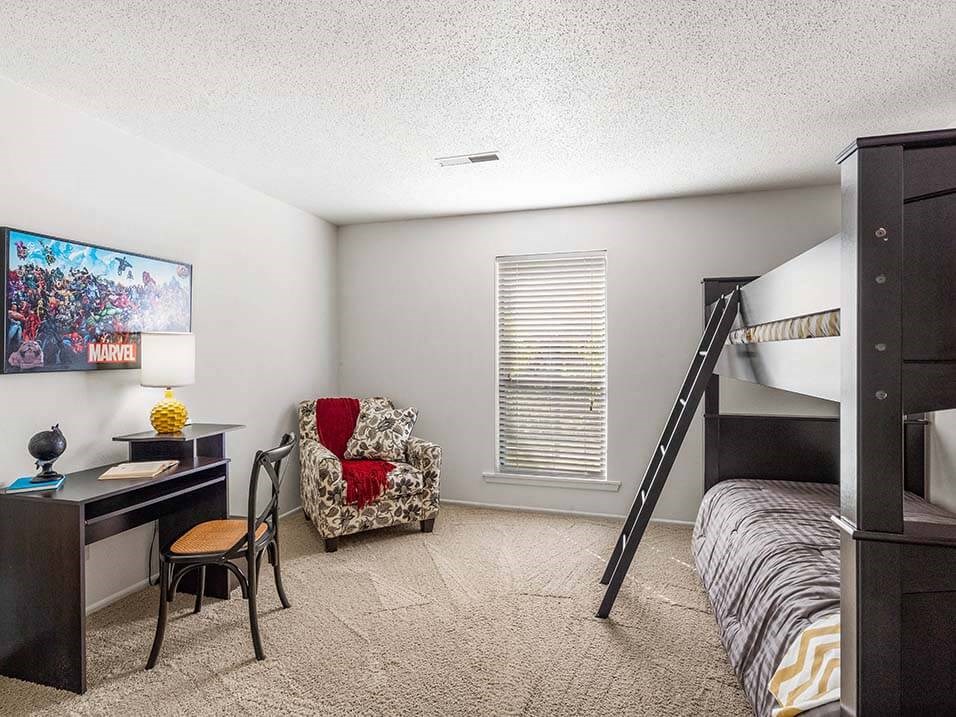 a bedroom with a bunk bed and a desk