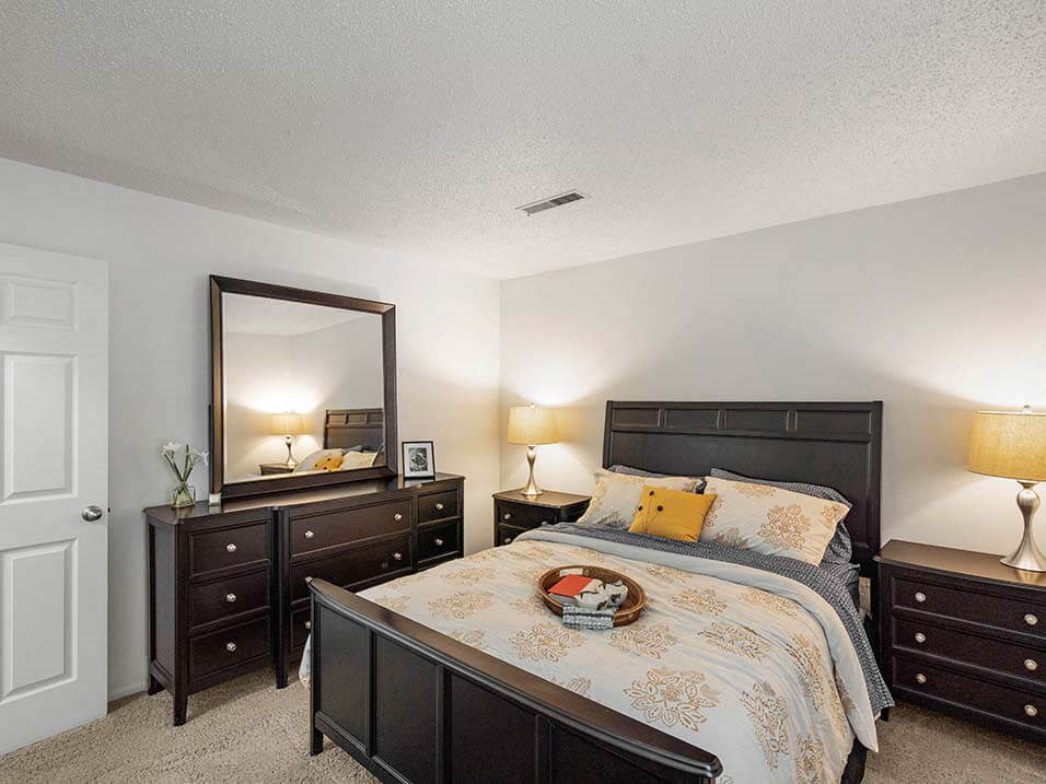 a bedroom with a bed and a mirror