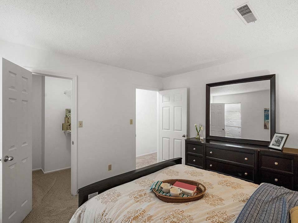 a bedroom with a bed and a mirror