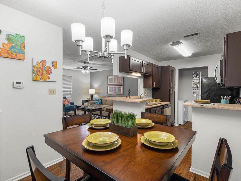 a kitchen and dining room with a table with plates on it
