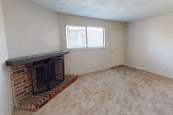 an empty living room with a fireplace and a window