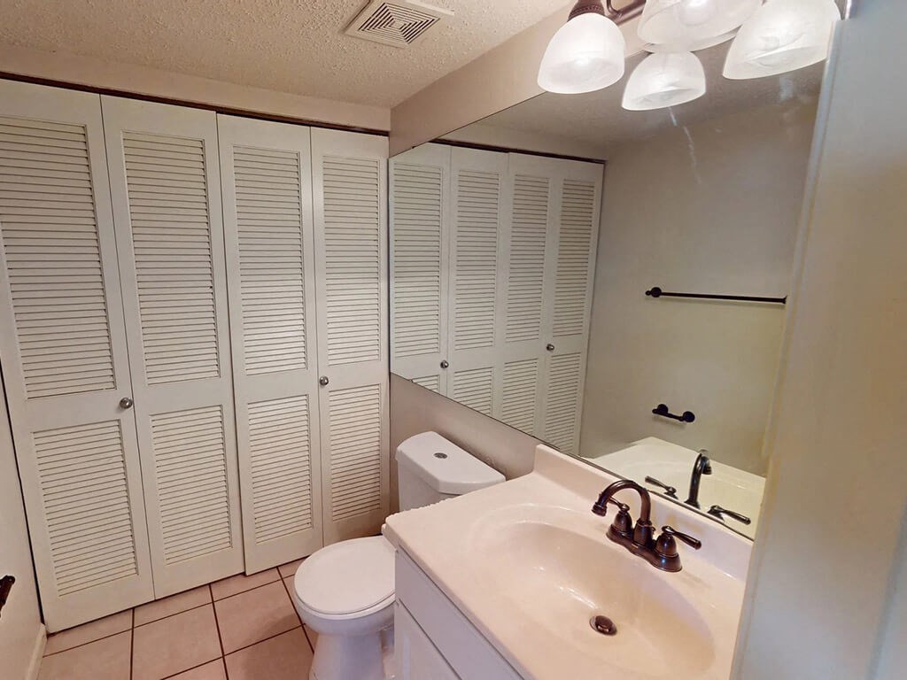 a bathroom with white cabinets and a sink and a toilet