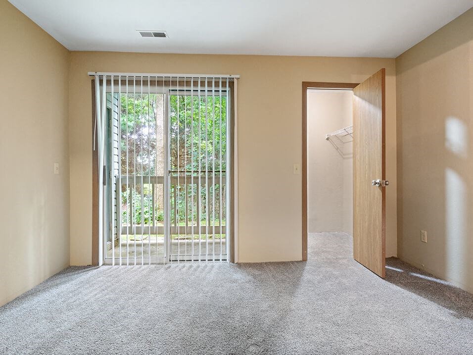 apartment living room with a sliding glass door and a closet