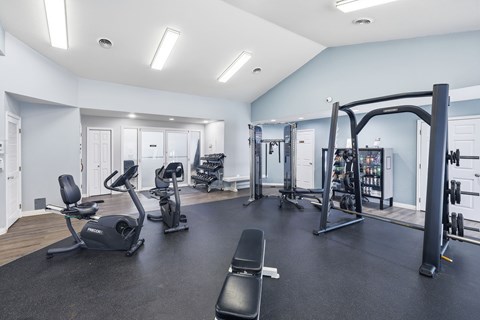 A spacious gym with a variety of equipment including treadmills, stationary bikes, and weight machines.