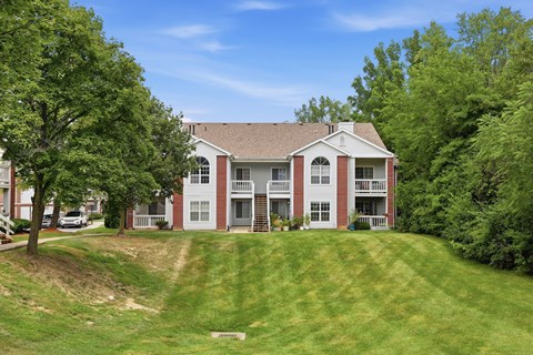 A red and white two story house with a green lawn in front.