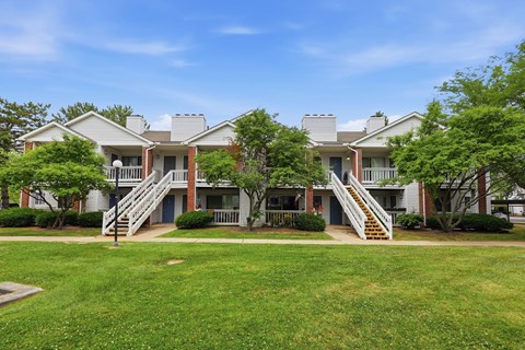 A row of houses with green lawns in front.