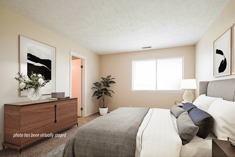 A bedroom with a bed, dresser, and window.