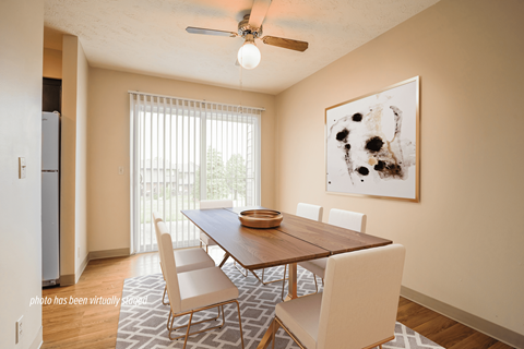 A dining room with a wooden table and chairs.