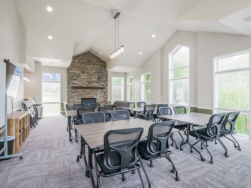 clubhouse with tables and chairs and a fireplace