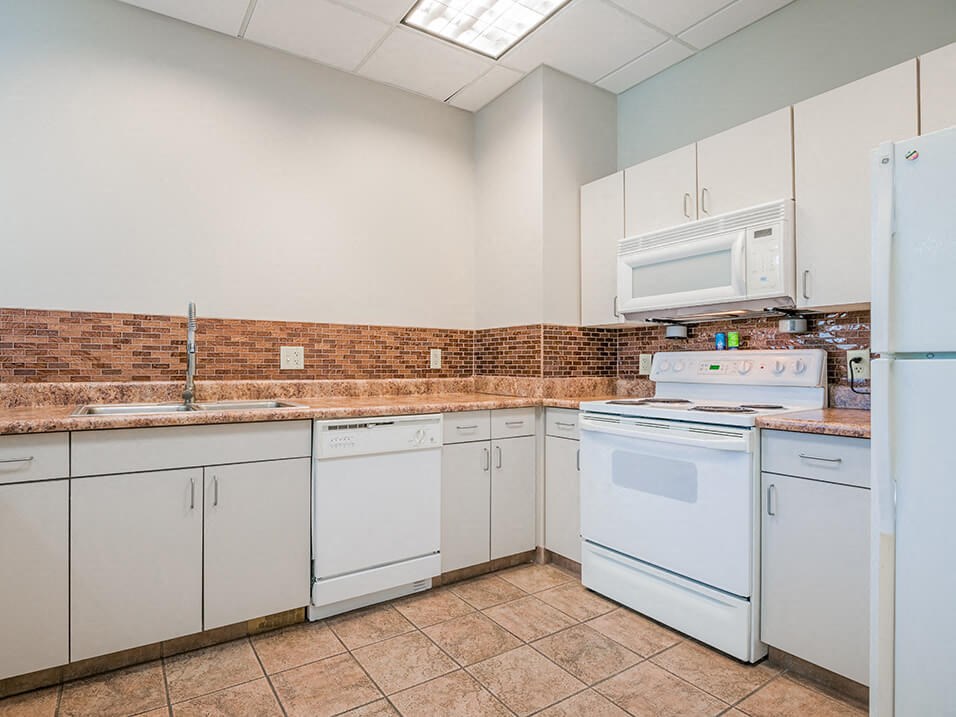 a kitchen with white appliances and white cabinets