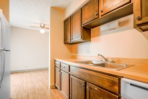 A kitchen with wooden cabinets and a white refrigerator.