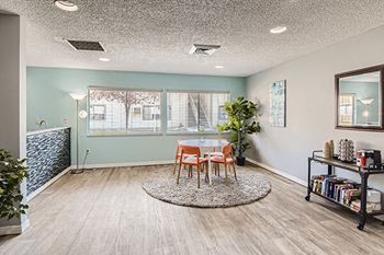 a dining area with a table and chairs in front of a window