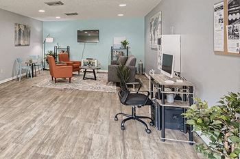 a living room with a computer desk and chairs