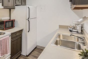 a kitchen with a sink a refrigerator and a microwave