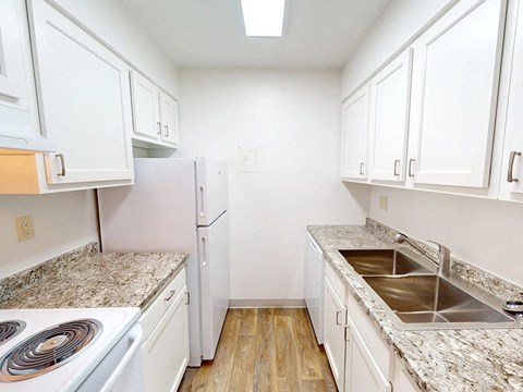 a kitchen with marble counter tops and white cabinets