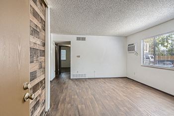 an open plan living room with a wooden accent wall