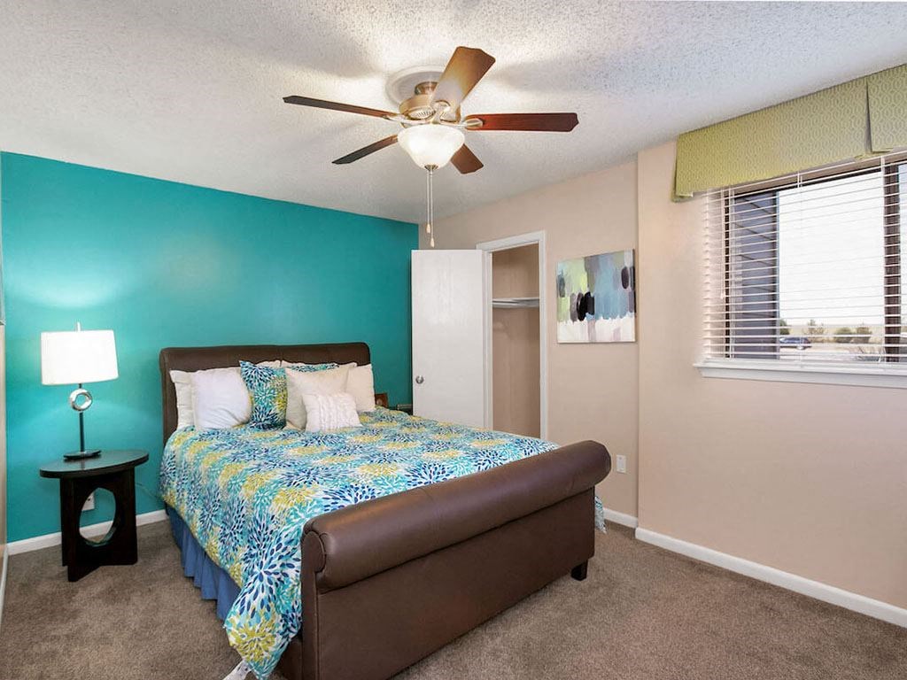 a bedroom with a bed and a ceiling fan