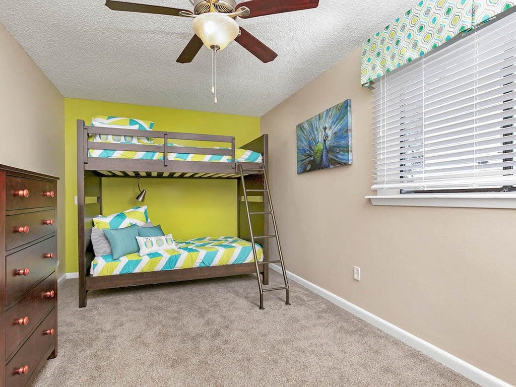 a bedroom with a bunk bed and a ceiling fan