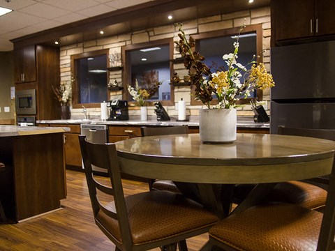 a kitchen with a round table with a vase of flowers on top of it