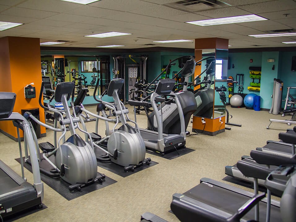 a room filled with cardio equipment and weights