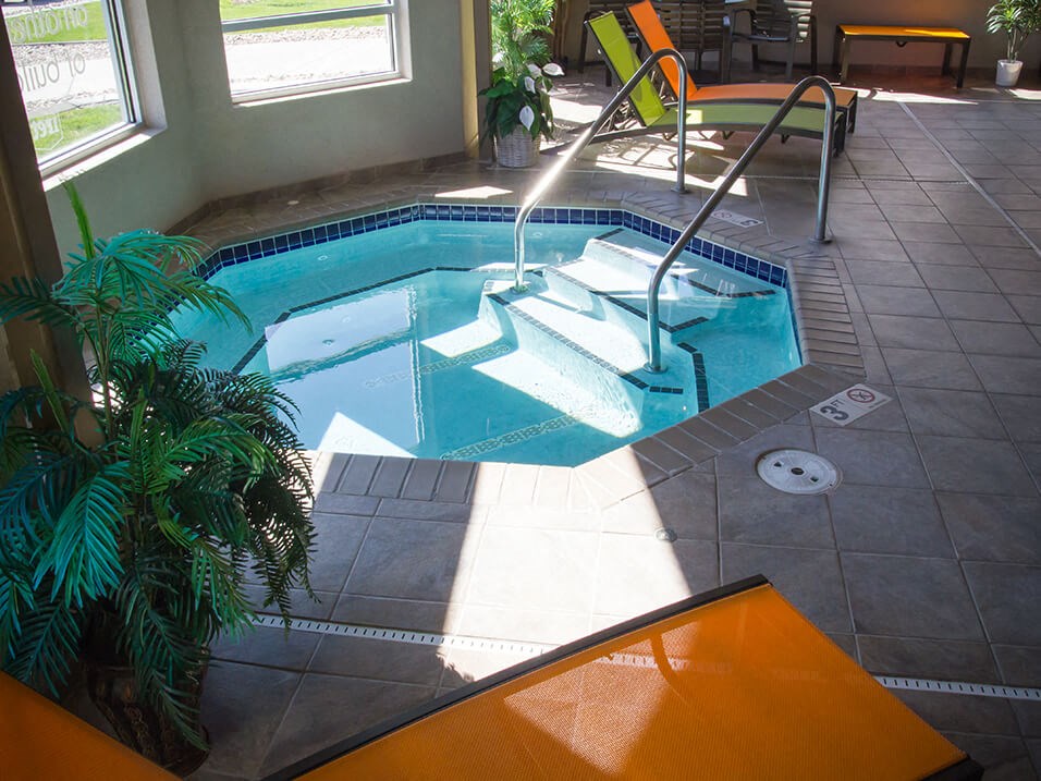 a plunge pool in a home with a tile floor and floor to ceiling windows