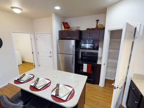 a kitchen with a table and chairs and a stainless steel refrigerator