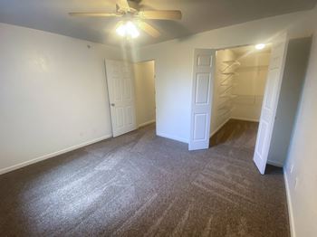 a bedroom with a ceiling fan and a closet