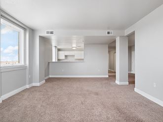 the living room and kitchen of an empty home with carpeting