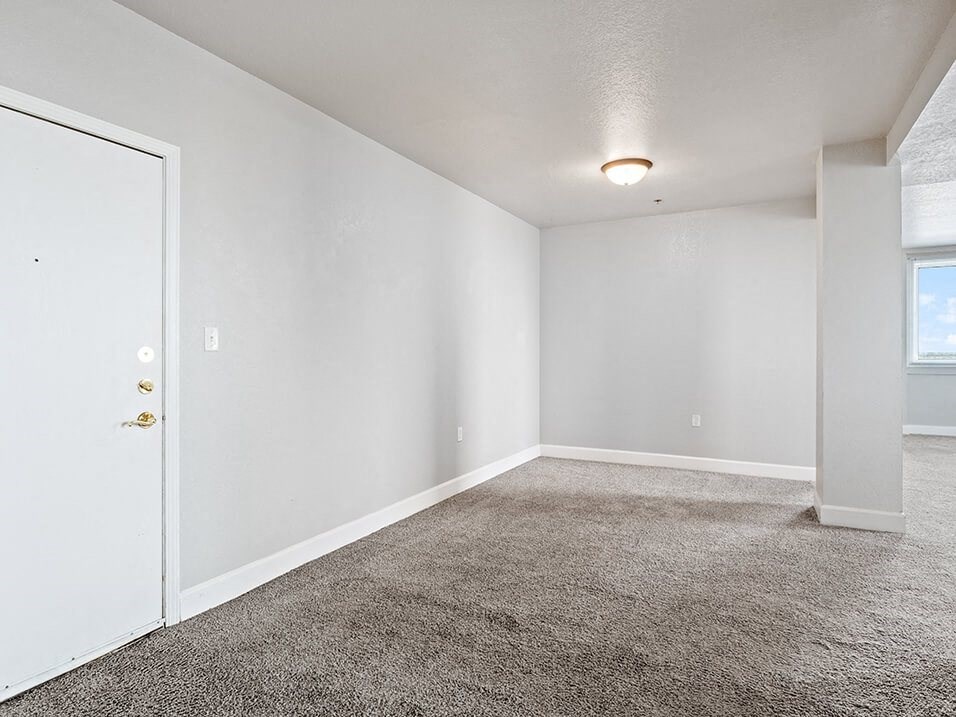 an empty living room with a door to a closet