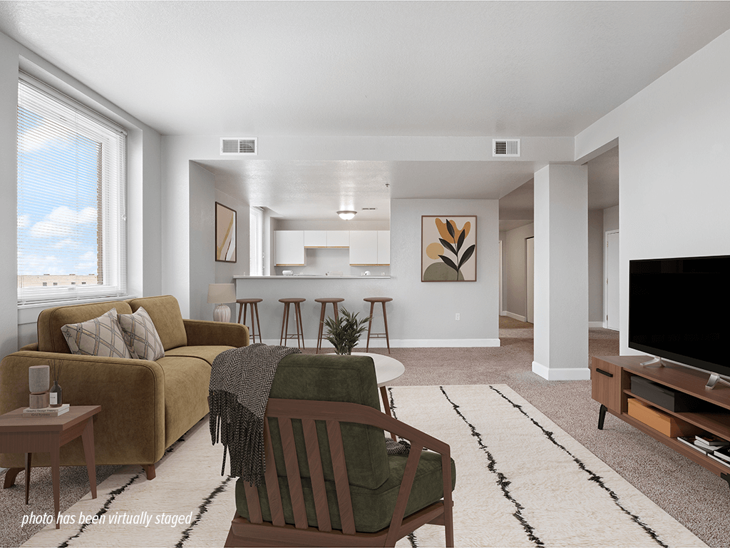 A living room with a couch, chair, and television.