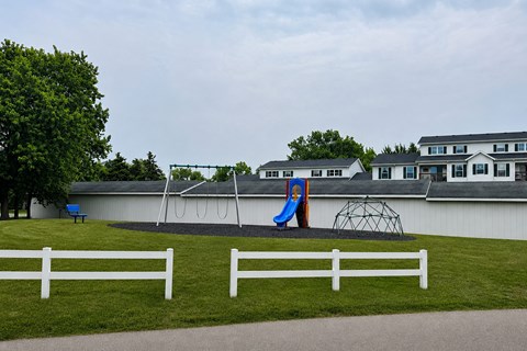 A playground with a slide and a swing set.